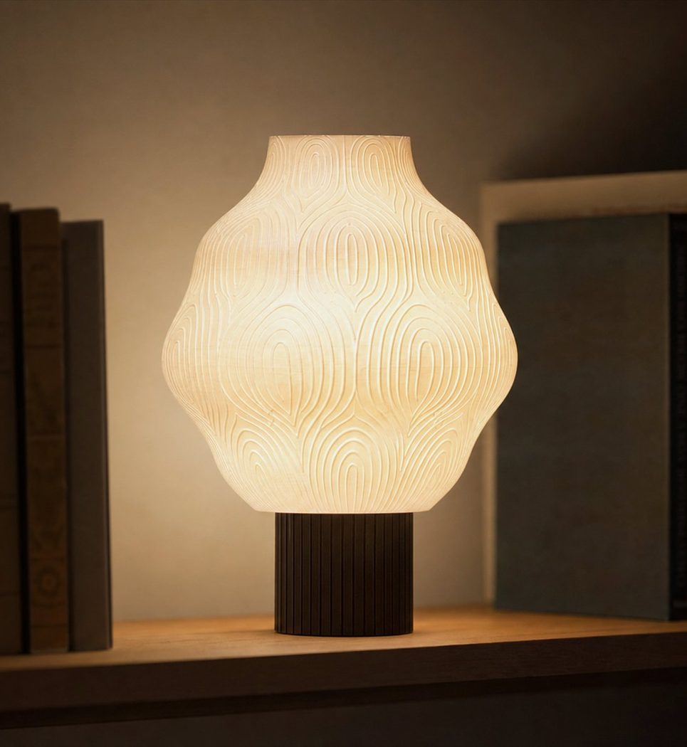 Lampa stołowa Arch Blossom zapalona na półce z książkami